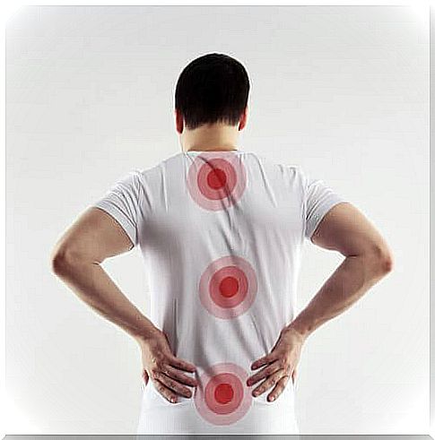 A man in a white t-shirt marked important points on the spine to restore the spinal cord.