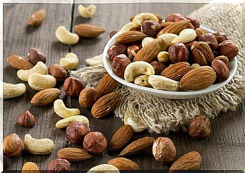 A small bowl is filled with various nuts, such as cashews or almonds.