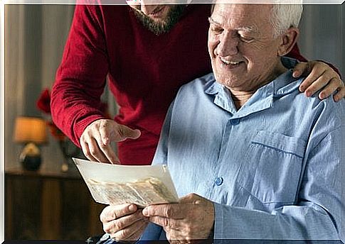 Elderly man looks at a photo