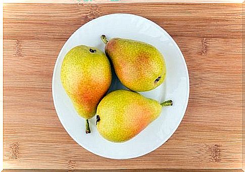 Three pears on a plate, as safe fruit for babies.